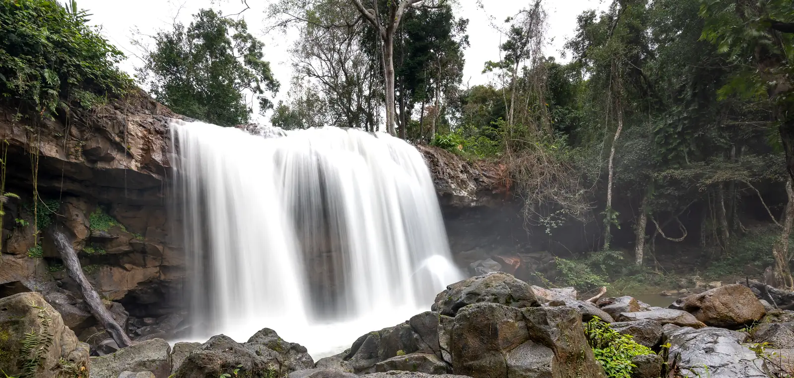 A waterfall running full through green forest at Khao Yai in the wet season